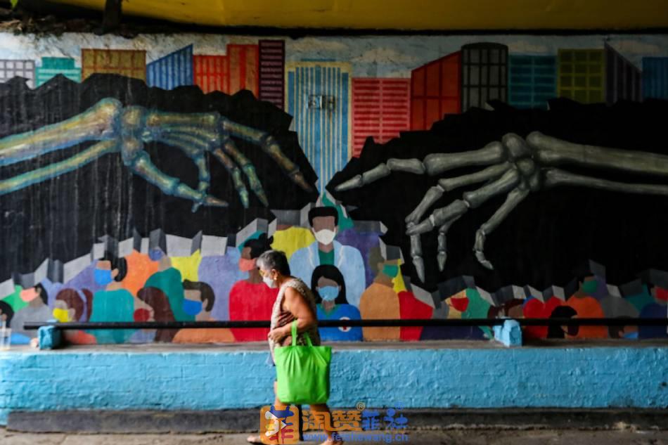 A  woman  walks  past  a  COVID-19 pandemic-themed  mural  at  an  underpass  in  Makati  City  on  July  18, 2022. Jonathan  Cellona, ABS-CBN  News