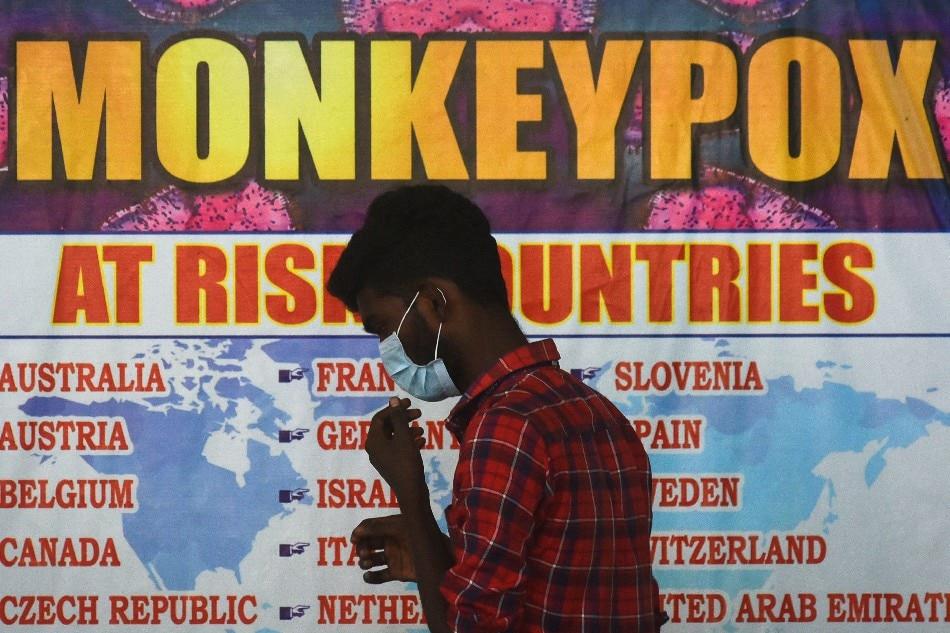 An  Indian  health  worker  walks  in  front  of  a  list  of  high-risk  countries  for  the  Monkeypox  virus, as  India  reported  the  first  case  of  monkeypox  in  the  WHO  South-East  Asia  Region, at  Chennai  International  Airport, in  Chennai, India, July  16, 2022. Idrees  Mohammed, EPA-EFE